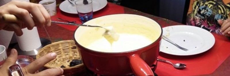 Private excursions to discover western Switzerland Family enjoying a fondue in Gruyères